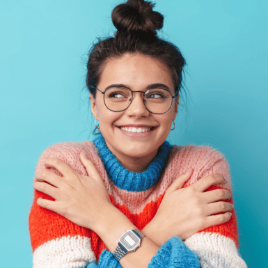 girl in glasses giving herself a hug